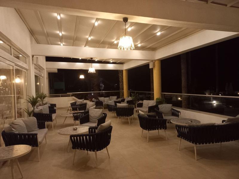 Osvětlená hotelová terasa s moderními stoly a židlemi v noci