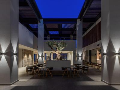 Cortile moderno dell'hotel di notte con area salotto e illuminazione decorativa.