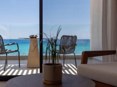Modern balcony with two chairs and sea view on a sunny day.