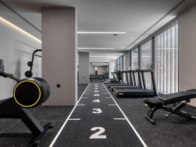 Palestra moderna con pista da corsa, tapis roulant e attrezzature in un hotel.