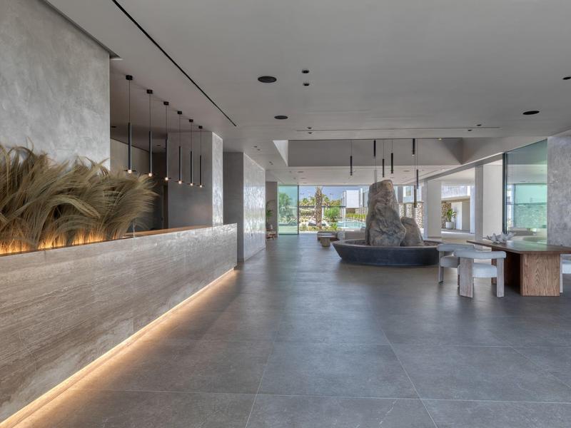 Modern hotel lobby with large stone fountain and minimalist decor.