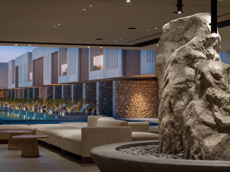 Modern hotel lobby with natural rock decoration and comfortable seating areas.