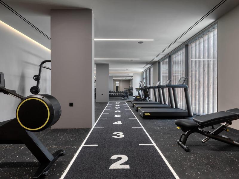 Modern gym with exercise machines and running track in hotel
