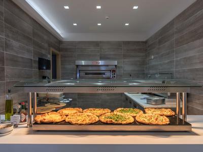 Bufet samoobsługowy z świeżo upieczonymi pizzami w nowoczesnej jadalni.