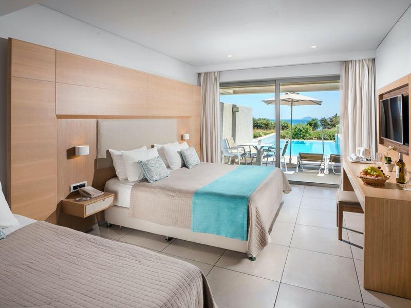 Nowoczesny pokój hotelowy z łóżkiem podwójnym, balkonem i widokiem na basen i morze.