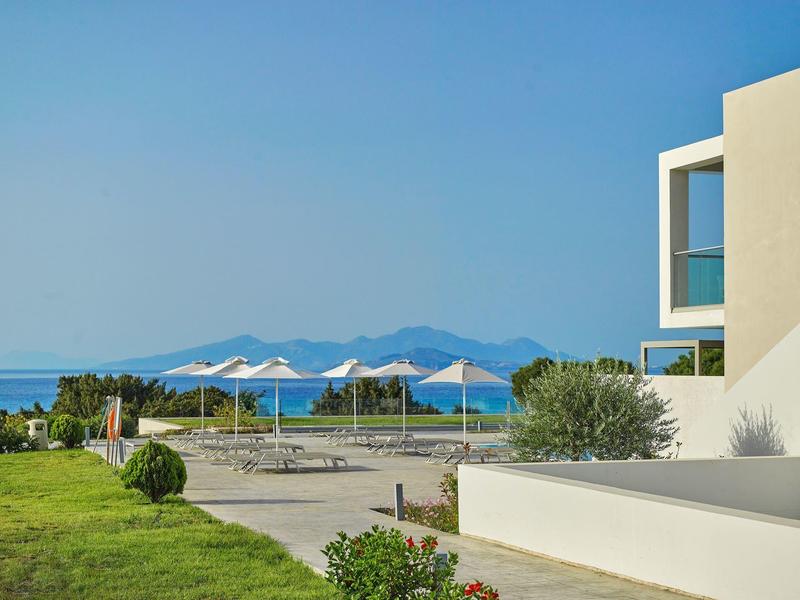 Nowoczesny basen hotelowy z białymi parasolami z widokiem na morze i góry