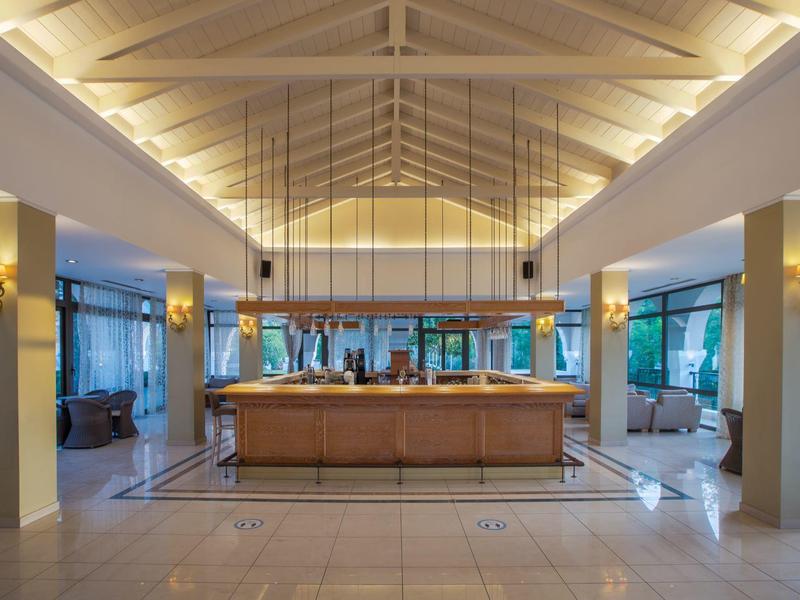 Jasno oświetlona lobby hotelowa z recepcją i nowoczesnym wystrojem.