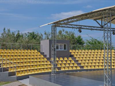 Lege gele zitplaatsen op overdekte tribunes met een blauwe lucht op de achtergrond