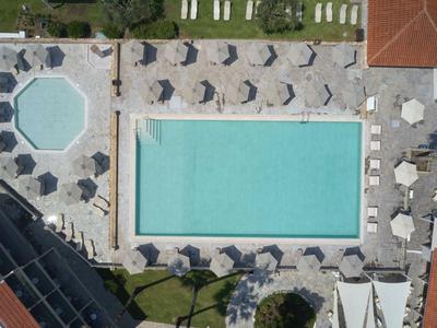 Luchtfoto van een rechthoekig zwembad omringd door ligstoelen en parasols.