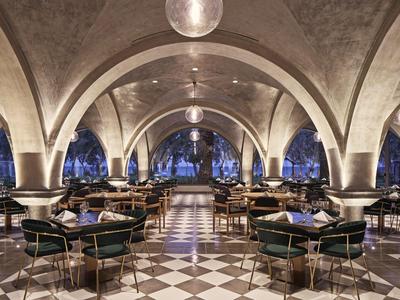 Eleganter Speisesaal mit gewölbten Decken und symmetrischen Bögen in gehobener Hotelatmosphäre.