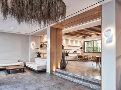 Moderner Hotellobbybereich mit Lounge-Möbeln, Holzakzenten und großen Fenstern.