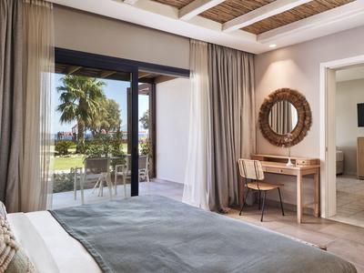 Modernes Schlafzimmer mit großem Fenster und Blick auf tropische Pflanzen.