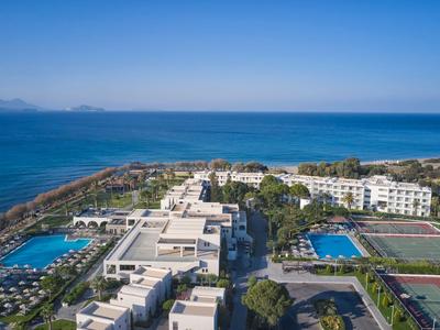 Hotelanlage am Meer mit Pool, Tennisplatz und Blick auf die Küste und das blaue Wasser.