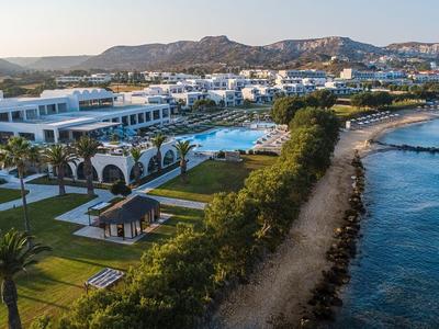 Luxuriöses Hotel mit Pool und direktem Zugang zur Küste, umgeben von Bergen.