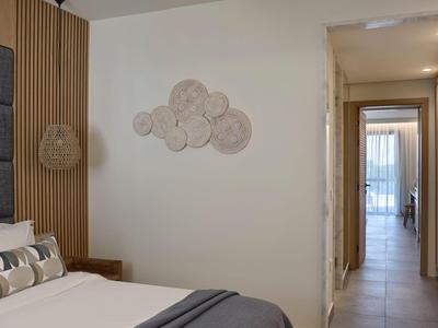 Helles Hotelzimmer mit dekorativer Wandgestaltung und Flur zu einem weiteren Raum.