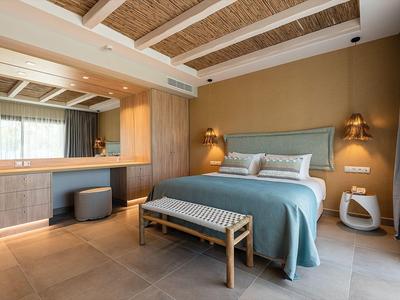 Modernes Schlafzimmer mit Holzdecke, Doppelbett, Sitzbank und großem Spiegel mit Schminktisch.