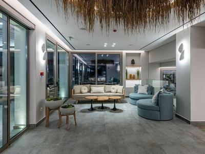 Modern gestalteter Hotel-Loungebereich mit Sitzmöbeln und großer Fensterfront.