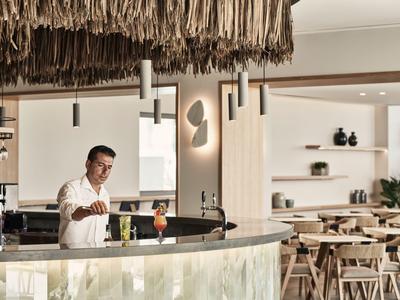 Bar in einem modernen Hotel mit Barkeeper und gemütlichen Sitzgelegenheiten.