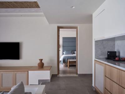 Moderner Wohnraum mit TV, Holzschrank, Vase und Blick in ein Schlafzimmer mit Bett.