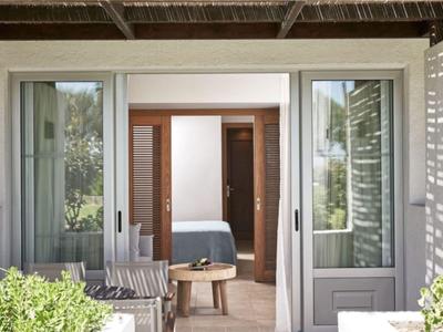 Moderner Eingang zu einem Hotelzimmer mit Glas-Schiebetüren und Sitzbereich außen