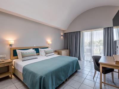 Modernes Hotelzimmer mit Doppelbett, Schreibtisch, Balkon und natürlichem Licht.