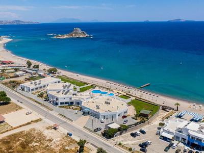 Veduta aerea di una località costiera con spiaggia, hotel e accesso al mare.