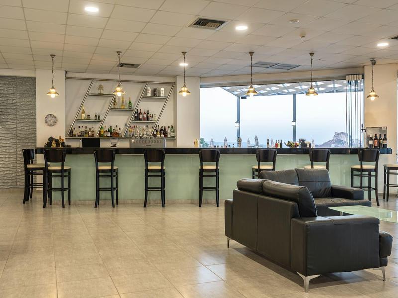 Area bar dell'hotel moderna con bancone, sgabelli e posti a sedere comodi.