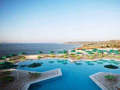 Grande piscine avec parasols verts avec vue sur la mer et la côte.