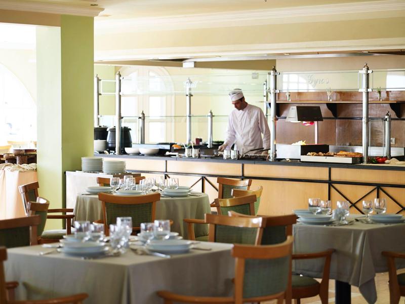 Restaurant élégant avec tables dressées et chef en arrière-plan