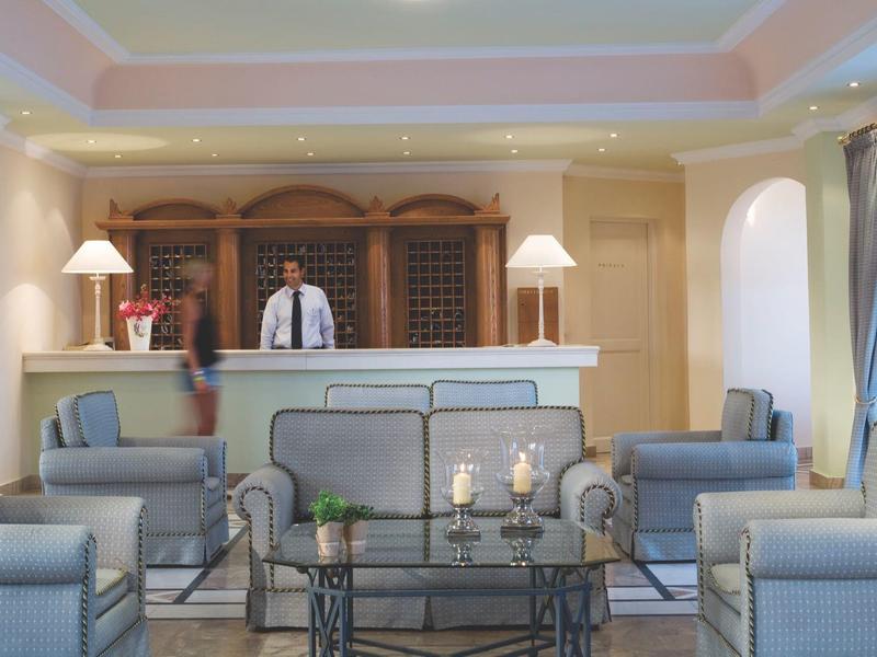 Réception d'hôtel avec réceptionniste et espaces de détente modernes dans une pièce lumineuse et élégante.