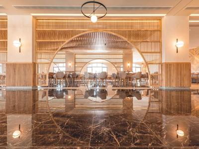 Ampia ed elegante hall dell'hotel con specchio rotondo e pavimento in marmo.