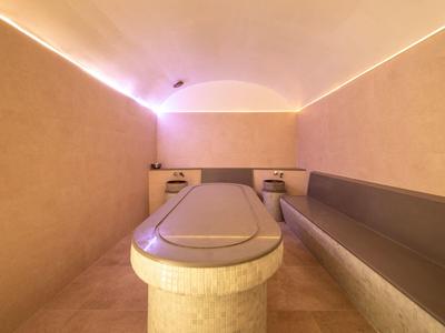 Una stanza rilassante con un lettino riscaldato e illuminazione soffusa in un'area spa.