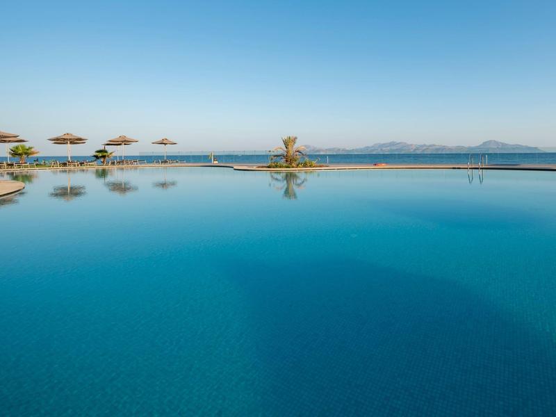 Piscina a sfioro con acqua blu limpida che si affaccia sul mare e l'orizzonte
