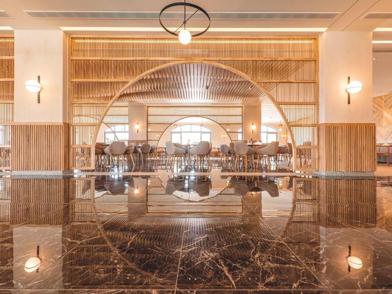 Ampia ed elegante hall dell'hotel con specchio rotondo e pavimento in marmo.