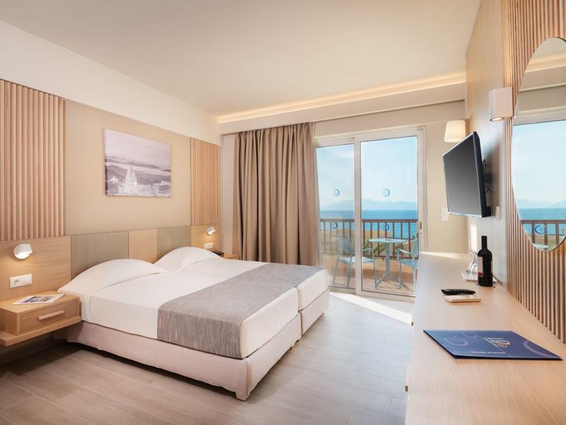 Camera d'hotel moderna con due letti singoli, vista mare e balcone