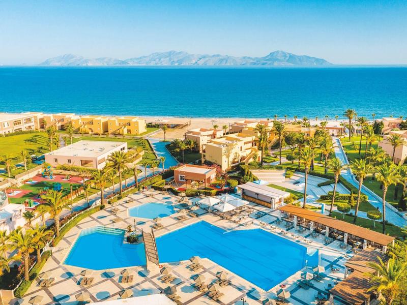 Grande resort con più piscine e vista sul mare e sulle isole sullo sfondo.