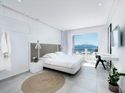 Camera d'albergo moderna con letto matrimoniale e balcone con vista mare