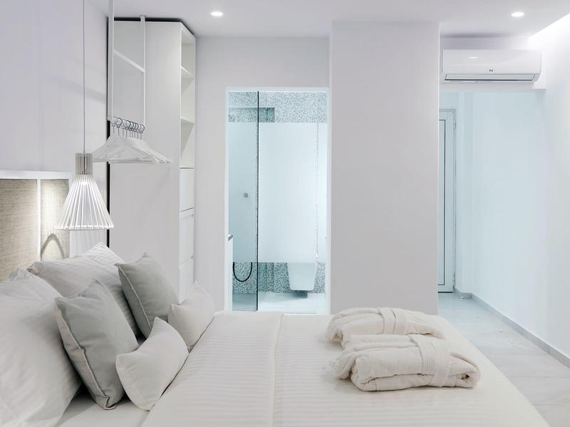 Camera d'hotel moderna con letto grande, cuscini morbidi e bagno elegante.