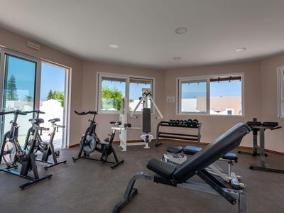 Una palestra ben attrezzata con cyclette, pesi e finestre con vista sull'area esterna.