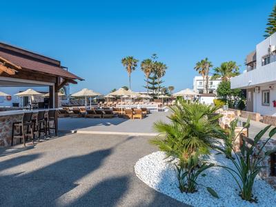 Terrazza dell'hotel con bar, lettini e piscina sotto un cielo azzurro limpido