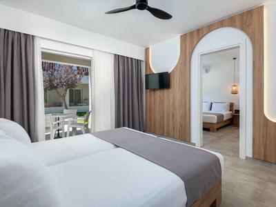 Camera d'hotel moderna con due letti, rivestimento in legno e accesso alla terrazza.