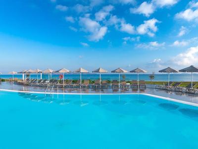 Grande piscina all'aperto con ombrelloni e lettini sotto un cielo blu