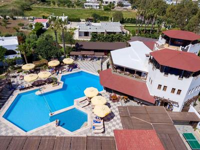 Widok z lotu ptaka na hotel z dużym basenem na świeżym powietrzu i leżakami pod parasolami.