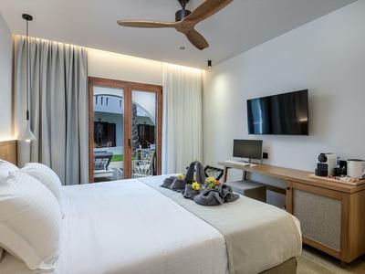 Nowoczesny pokój hotelowy z podwójnym łóżkiem, balkonem, telewizorem, biurkiem i ekspresem do kawy.