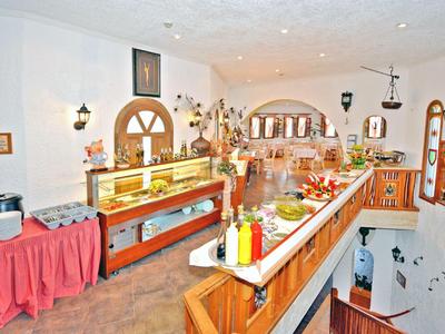 Ein heller, gemütlicher Frühstücksraum mit Buffet und Sitzbereichen in einem Hotel.