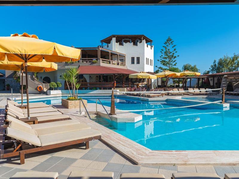 Słoneczny teren basenu na zewnątrz z leżakami i żółtymi parasolami w kurorcie.