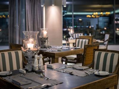 Area ristorante moderna con tavoli apparecchiati e illuminazione soffusa.