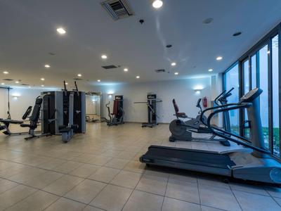 Grande palestra con molteplici attrezzi e grandi finestre che si affacciano all'esterno.