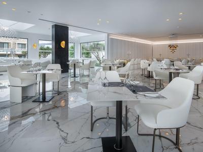 Bright, modern café with white chairs, tables, and marble flooring