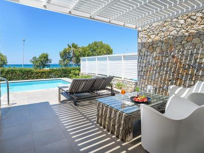 Modern outdoor area with seating and pool view under a covered patio.